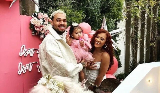 Chris Brown with her daughter in his arms with Diamond Brown standing next to him